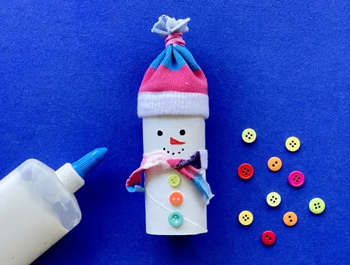Una madre y su hija pequeña haciendo manualidades con rollos de papel higiénico para Navidad.