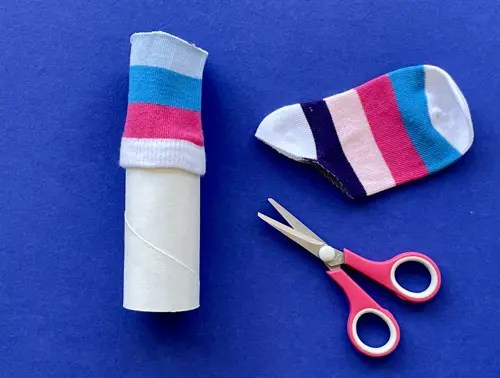 Una madre y su hija pequeña haciendo manualidades con rollos de papel higiénico para Navidad.