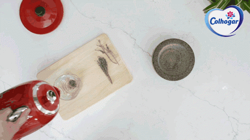 Un GIF de una mano con una tetera roja sirviendo un vaso de agua en una cocina.