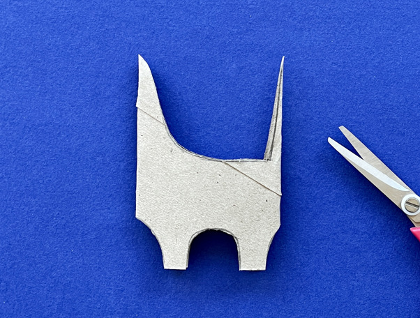 Una madre y su hija haciendo manualidades de animales con rollos de papel higiénico en el escritorio.