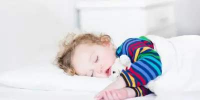 Niña durmiendo en una cama