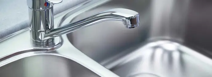 Un fregadero de aluminio limpio y reluciente. 