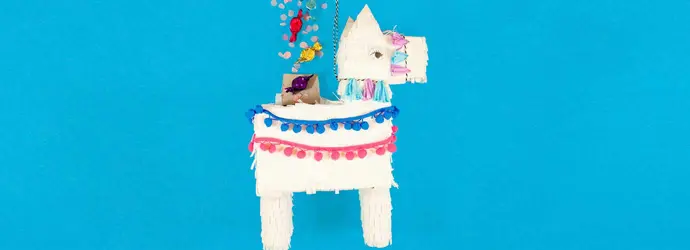 Piñata de llama blanca cubierta con papel de seda con flecos y dulces que caerán de la parte superior