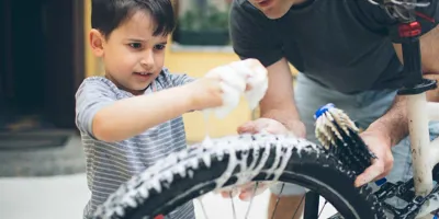 Padre e hijo limpiando una bicicleta