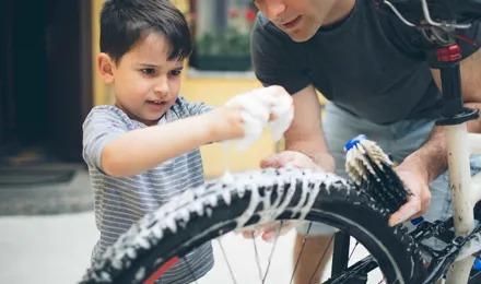 Padre e hijo limpiando una bicicleta