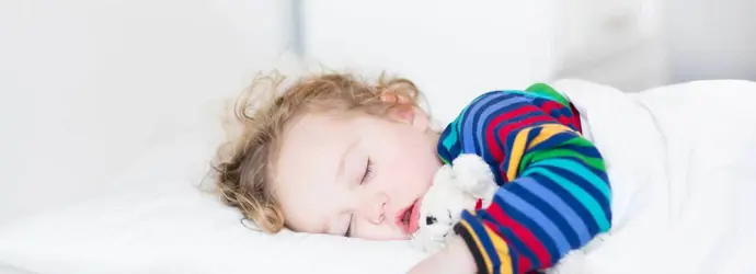 Uma rapariga pequena a dormir numa cama