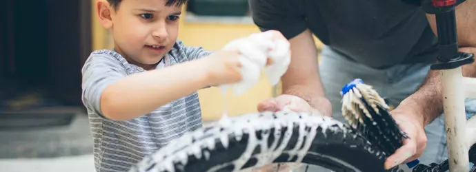 Pai e filho a limpar uma bicicleta