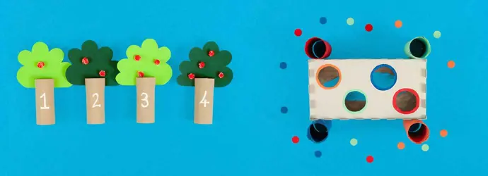 Jogos para o desenvolvimento de habilidades motoras finas feitos de tubos de papel higiénico vazios e decorados e uma caixa de lenços de papel