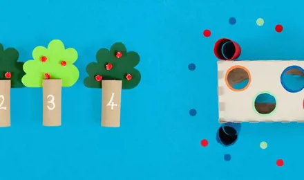 Jogos para o desenvolvimento de habilidades motoras finas feitos de tubos de papel higiénico vazios e decorados e uma caixa de lenços de papel