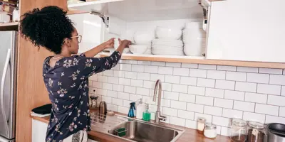 Uma mulher a organizar a cozinha