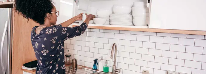 Uma mulher a organizar a cozinha