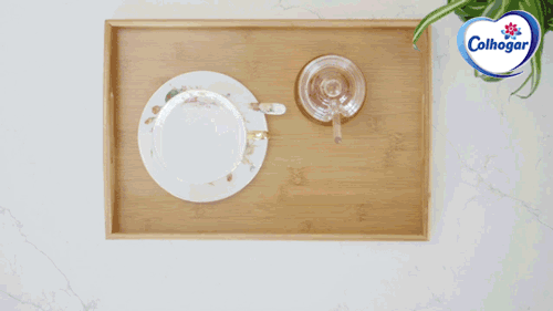 Un GIF de una bandeja con una taza, un recipiente con miel y un limón partido.