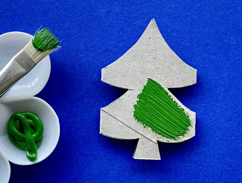 Una madre y su hija pequeña haciendo manualidades con rollos de papel higiénico para Navidad.