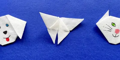 Unos niños haciendo animales fáciles en origami con papel de colores en su habitación.