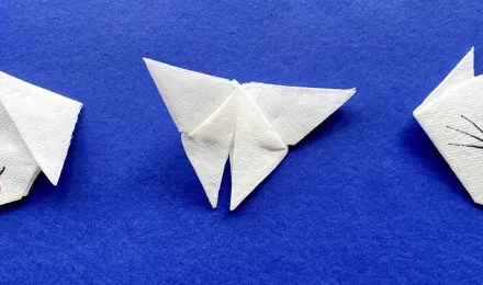 Unos niños haciendo animales fáciles en origami con papel de colores en su habitación.