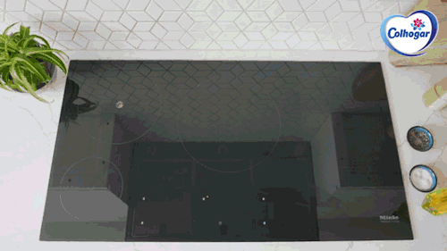 Un GIF de una mano colocando un cazo con agua en una placa de inducción.