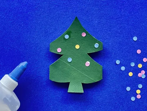 Una madre y su hija pequeña haciendo manualidades con rollos de papel higiénico para Navidad.
