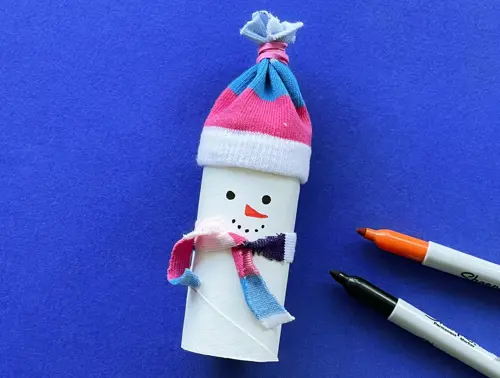 Una madre y su hija pequeña haciendo manualidades con rollos de papel higiénico para Navidad.