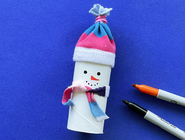 Una madre y su hija pequeña haciendo manualidades con rollos de papel higiénico para Navidad.