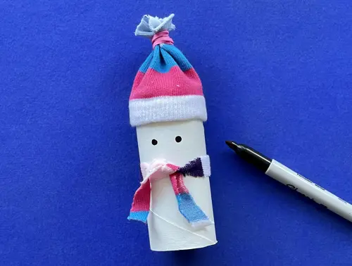 Una madre y su hija pequeña haciendo manualidades con rollos de papel higiénico para Navidad.