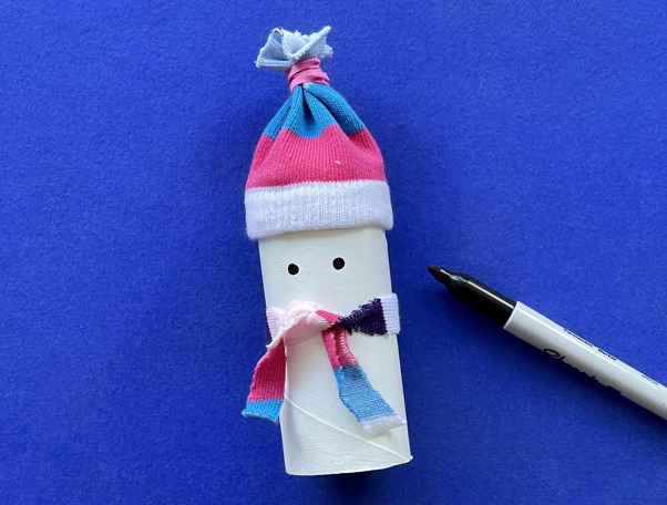 Una madre y su hija pequeña haciendo manualidades con rollos de papel higiénico para Navidad.