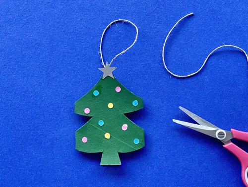Una madre y su hija pequeña haciendo manualidades con rollos de papel higiénico para Navidad.