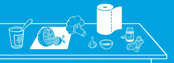 Avó, mãe e filha riem enquanto cortam legumes na cozinha para reforçar sistema imunitário naturalmente