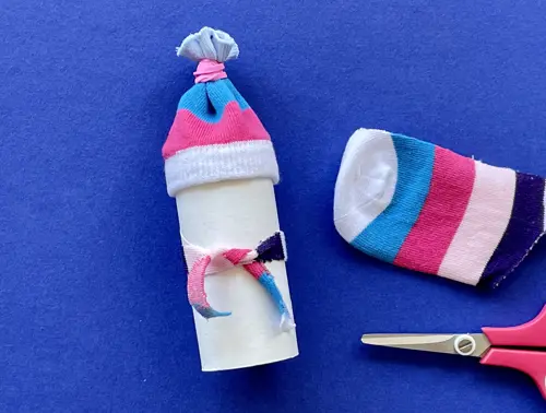Una madre y su hija pequeña haciendo manualidades con rollos de papel higiénico para Navidad.
