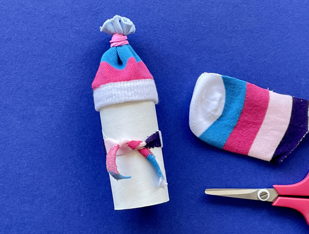 Una madre y su hija pequeña haciendo manualidades con rollos de papel higiénico para Navidad.